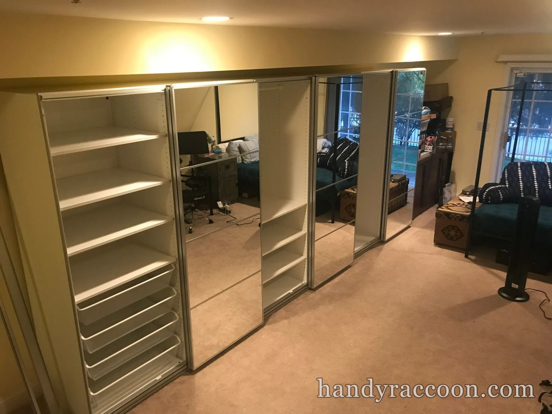 Several assembled wardrobe units with mirrored doors and white interior shelves on carpet