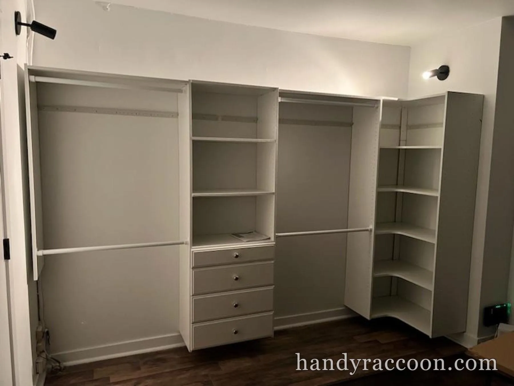 White reach-in closet organizer with open shelves, four drawers, corner shelving, and hanging rods.