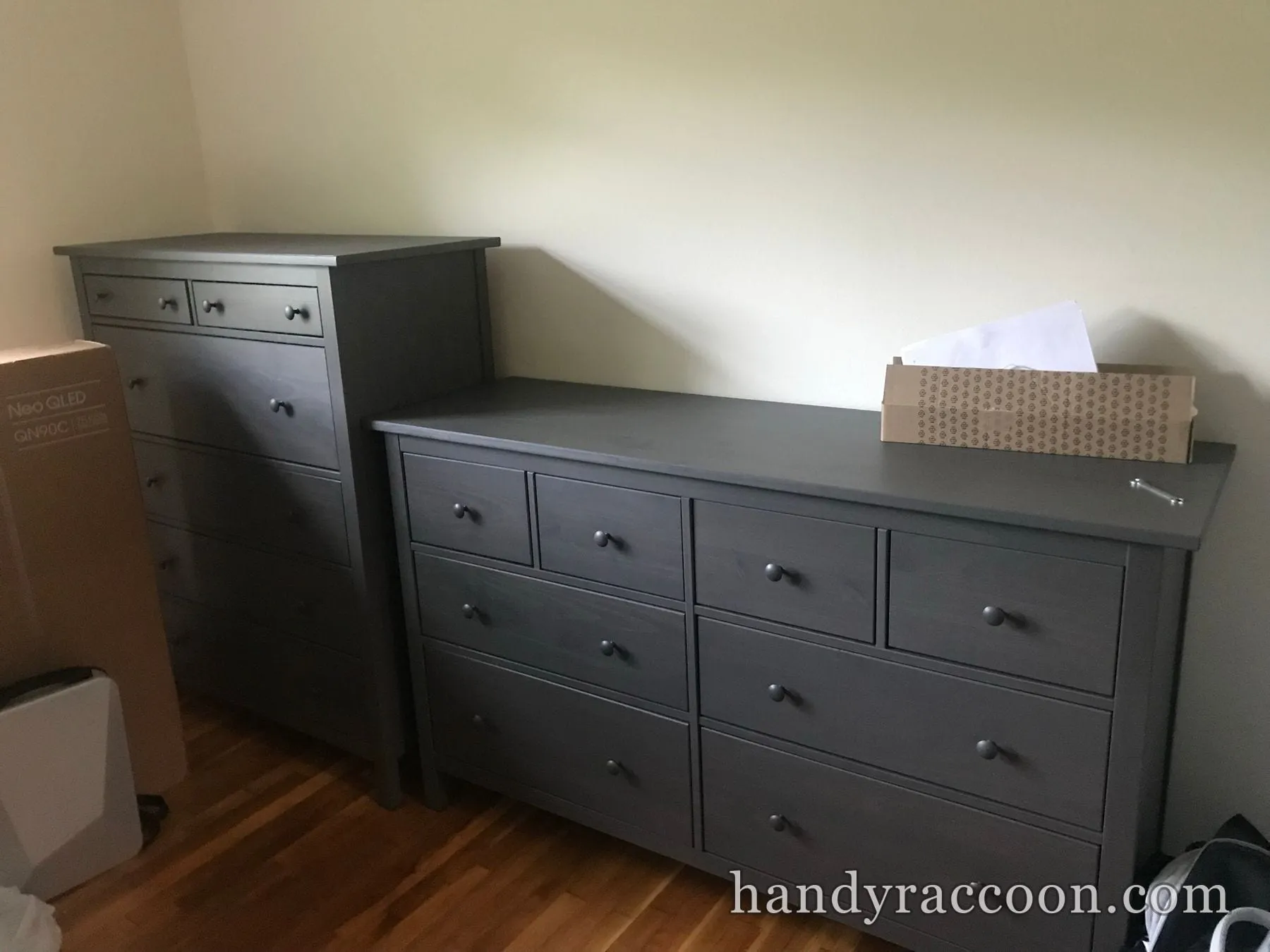 A tall grey chest of drawers and a wide grey dresser assembled along a bedroom wall.