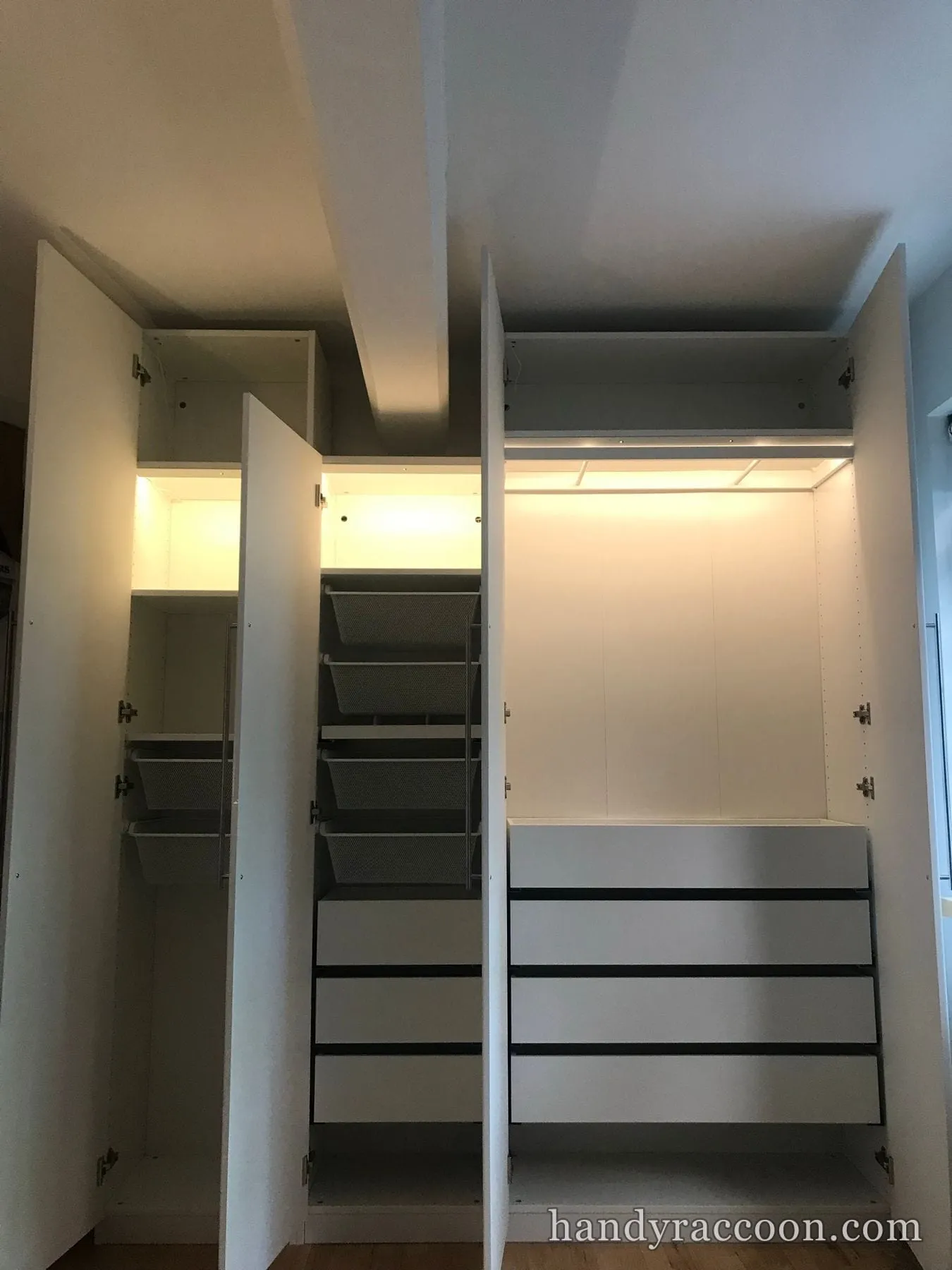 Open wardrobe interiors fitted with pull-out wire baskets, drawers, and interior LED lighting.