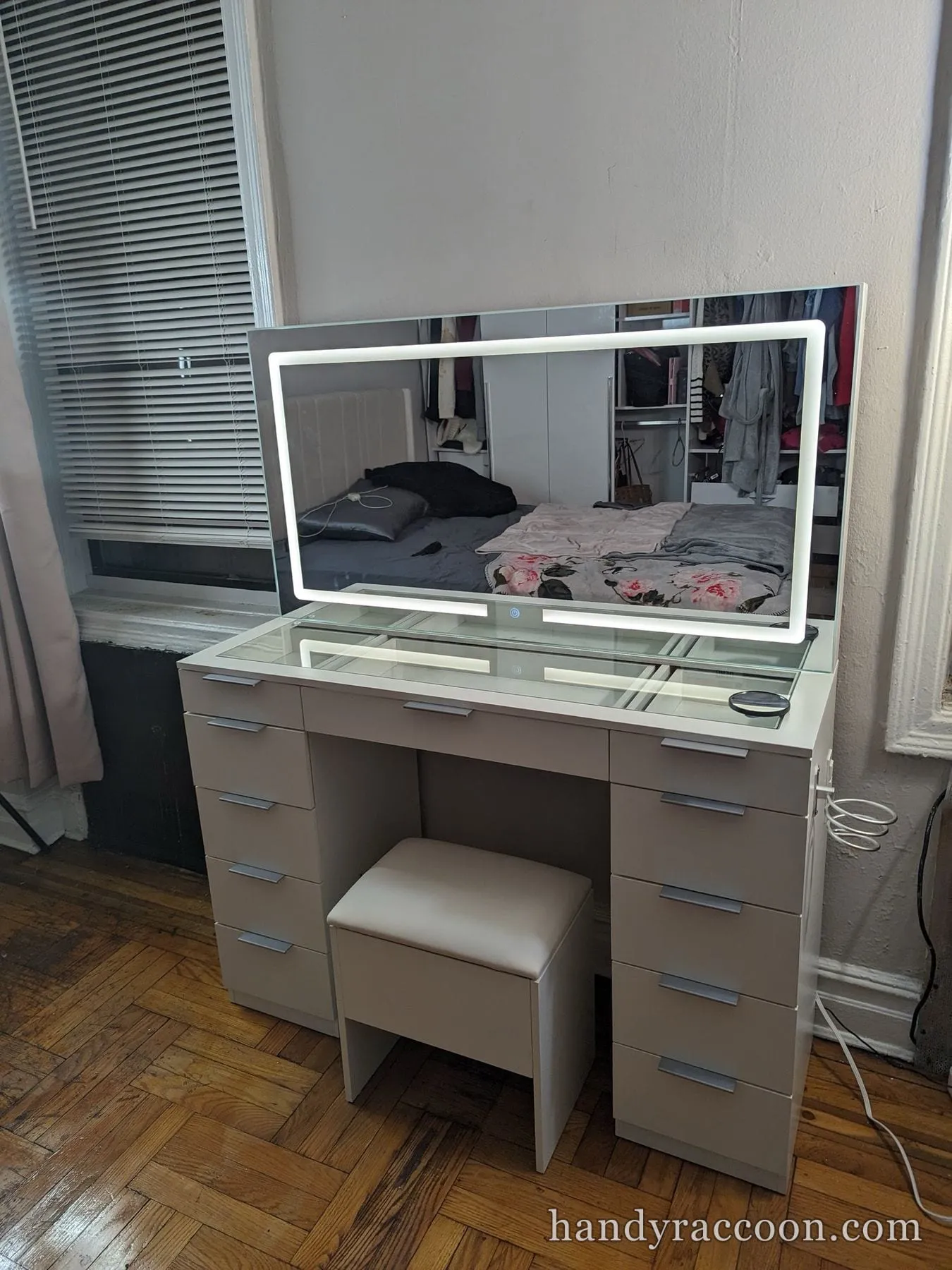 Taupe LED-lit vanity table with drawers, lit mirror, and upholstered stool assembled.