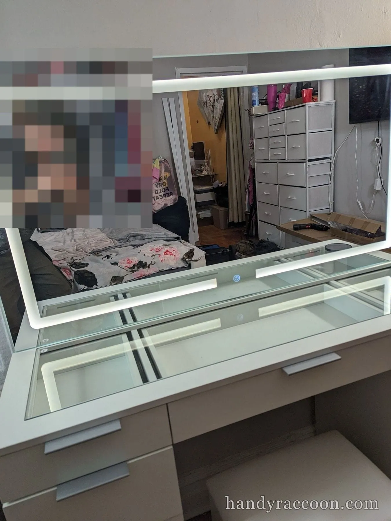 Close view of an assembled LED vanity mirror lit up, with a person reflected in it.