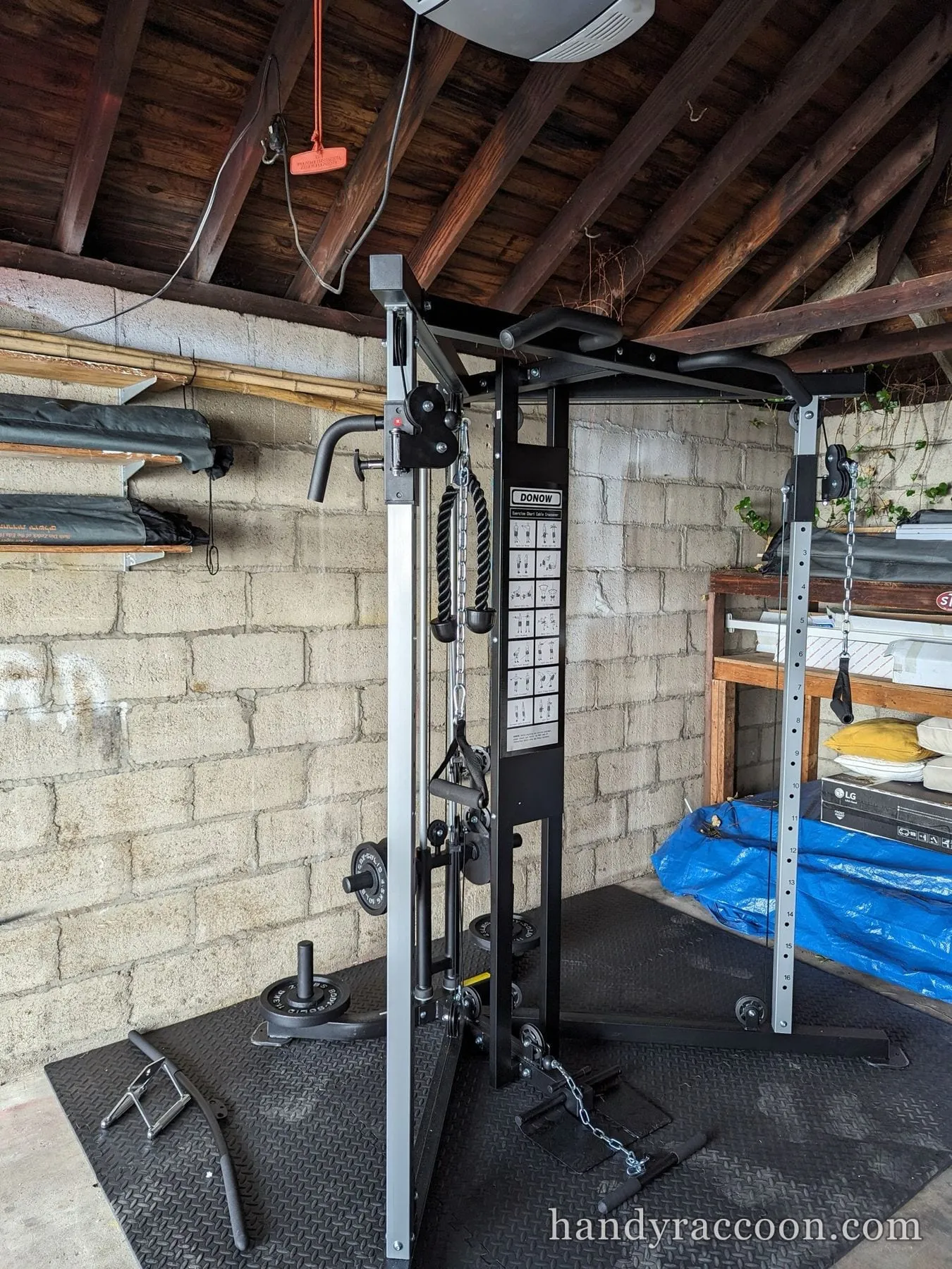 Black and silver cable crossover functional trainer set up in a garage.