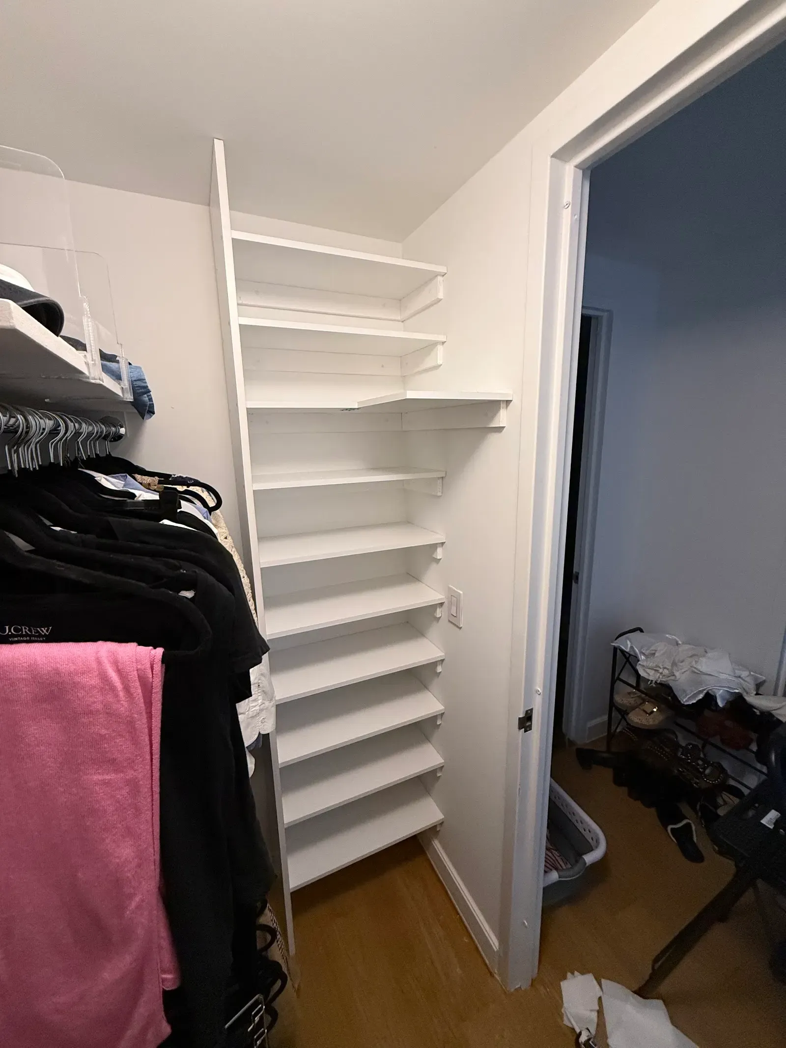 Custom white corner shelving built inside a walk-in closet