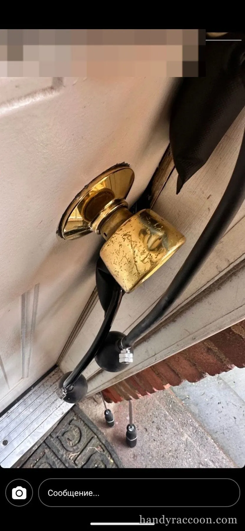 Brass door knob on a building entry door, photographed in a phone screenshot overlay.