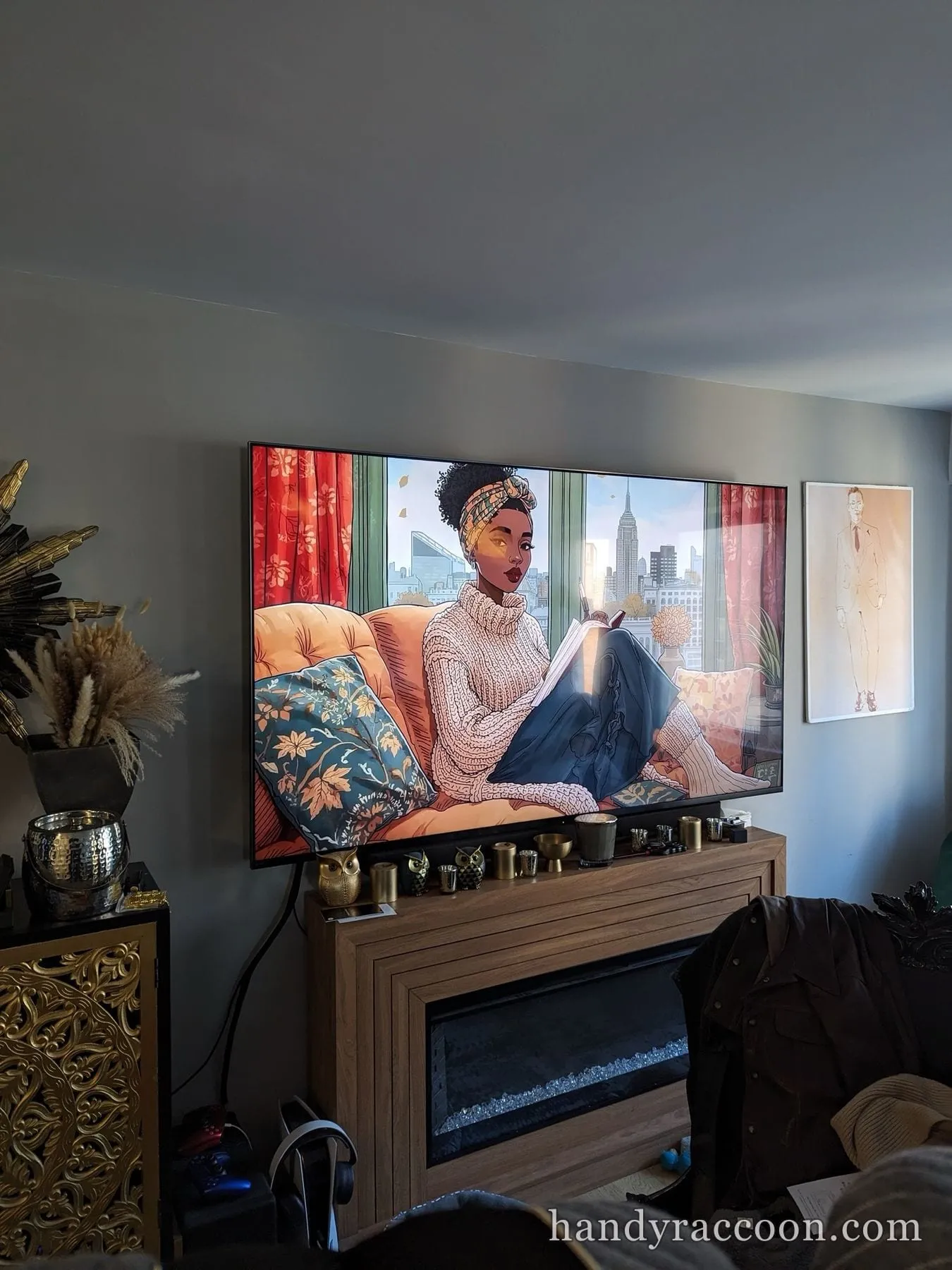 Large TV mounted above a wood console and electric fireplace, showing an illustrated artwork.